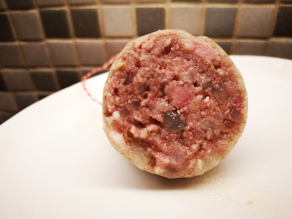 Meneer maakt cotechino, warme Italiaanse worst met zwoerd