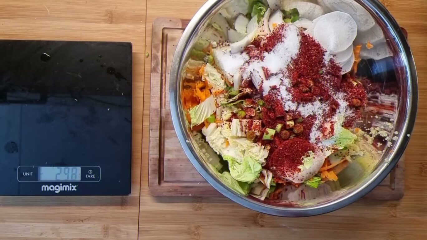 Alle ingrediënten voor kimchi in een kom op de weegschaal, met zout