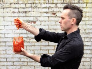 Meneer Wateetons knijpt zelfgemaakte kimchi uit boven een weckpot